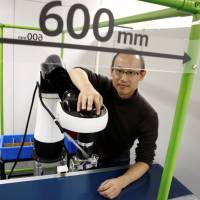 Life Robotics CEO Yoon Woo-keun poses with the robotic arm CORO at his company in Tokyo on Dec. 2. Japan experiencing budding startup wave as fundraising environment improves