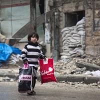 A Syrian boy is seen among other civilains leaving a rebel-held area of Aleppo toward the government-held side on Tuesday during an operation by Syrian government forces to retake the embattled city. | AFP-JIJI