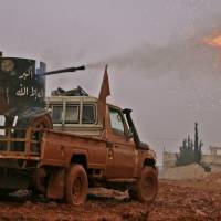 Syrian opposition fighters fire toward positions held by Islamic State (IS) group jihadis in al-Bab on the northeastern outskirts of the northern embattled city of Aleppo on Tuesday. | AFP-JIJI