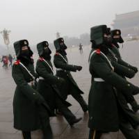Paramilitary policemen leave after a flag-raising ceremony amid heavy smog in Beijing\'s Tiananmen Square in December 2015. | REUTERS