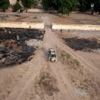 Soldiers stand near a military vehicle in Bama, northeast Nigeria, Dec. 8. The Nigerian army has defeated Boko Haram in the Sambisa forest, one of the jihadis\' last remaining strongholds, President Muhammadu Buhari said on Saturday. | AFP-JIJI