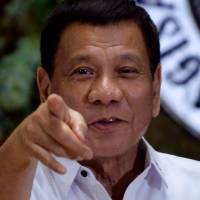 Philippine President Rodrigo Duterte points to photographers during an awards ceremony for outstanding government workers at the Malacanang Palace in Manila on Monday. | REUTERS
