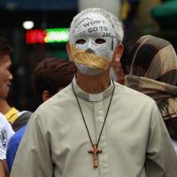 Manila Auxiliary Bishop Broderick Pabillo (right) and the Rev. Robert Reyes participate in a protest against alleged extrajudicial killings in Manila on Wednesday. | AP