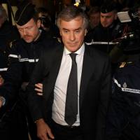 Former French budget minister Jerome Cahuzac, who resigned in 2013 after he admitted to having a Swiss bank account, is surrounded by French gendarmes as he leaves after the verdict in his tax fraud trial in Paris on Thursday. | REUTERS