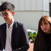 Pro-independence lawmakers Baggio Leung (left) and Yau Wai-ching arrive to speak to reporters outside the High Court in Hong Kong on Wednesday. | AFP-JIJI