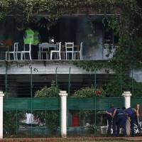 Policemen view the Holey Artisan cafe in Dhaka on July 3 after gunmen murdered 22 people. | REUTERS