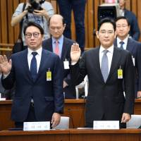 SK Group chairman Chey Tae-won (left), Samsung Group heir-apparent Lee Jae-yong (center) and Lotte Group Chairman Shin Dong-bin take an oath during a parliamentary probe into a scandal engulfing the administration of South Korean President Park Geun-hye at the National Assembly in Seoul on Tuesday. | REUTERS
