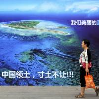 A billboard in Weifang, China, in July shows an island in the South China Sea and reads in part, \"Our beautiful motherland, we won\'t let go of an inch.\" | AP