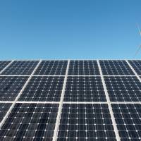 A wind turbine is seen over the panels of a solar power plant that belongs to Korea South East Power Co. in Incheon in this file photo. World energy hits a turning point: solar that's cheaper than wind