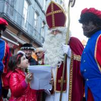 St. Nicholas is escorted by two assistants called Black Pete during a traditional parade in central Brussels on Saturday. | REUTERS