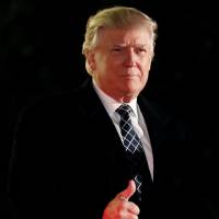 U.S. President-elect Donald Trump gives a thumbs up to the media as he arrives at a party at the home of hedge fund billionaire and campaign donor Robert Mercer in Head of the Harbor, New York, on Saturday. | REUTERS