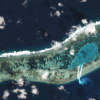 Sand can be seen spilling from a newly dredged channel in this view of Vietnamese-held Ladd Reef, in the Spratly Island group in the South China Sea, Nov. 30in this Planet Labs handout photo received by Reuters on Tuesday. | TREVOR HAMMOND / PLANET LABS / HANDOUT VIA REUTERS