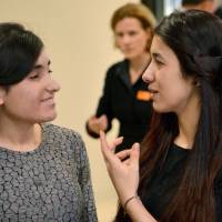 Nadia Murad, U.N. Goodwill Ambassador for the Dignity of Survivors of Human Trafficking, gestures to Lamiya Aji Bashar after both received the 2016 the European Parliament\'s prestigious Sakharov human rights prize Thursdayk at the Landtag state pariament of Baden-Wuerttemberg in Stuttgart, Germany. | FRANZISKA KRAUFMANN / DPA / AFP-JIJI