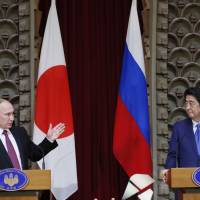 Russian President Vladimir Putin speaks as Prime Minister Shinzo Abe looks on during a news conference in Tokyo on Friday. Russia and Japan agreed to hold talks on the joint economic development of four islands at the center of a territorial dispute. | AP