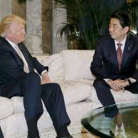 Prime Minister Shinzo Abe speaks with U.S. president-elect Donald Trump in New York on Nov. 18. | AFP-JIJI