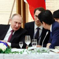 Russian President Vladimir Putin (left) confers with Prime Minister Shinzo Abe during a working lunch in Tokyo on Friday. | AFP-JIJI