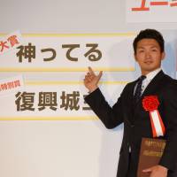 Hiroshima Toyo Carp outfielder Seiya Suzuki points to the buzzword of the year, kamitteru, or superhuman behavior, at an awards ceremony in Tokyo on Thursday. | SATOKO KAWASAKI