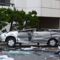 The wreckage of a car that drove off the fifth floor of a parking garage in Yokosuka, Kanagawa Prefecture, on Saturday with five people inside is seen here. Three adults were killed in the incident while two children suffered injuries. | KYODO