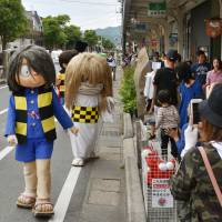 Characters based on spirits and monsters participate in a parade on Mizuki Shigeru Road in Sakaiminato, Tottori Prefecture, on June 4. | KYODO
