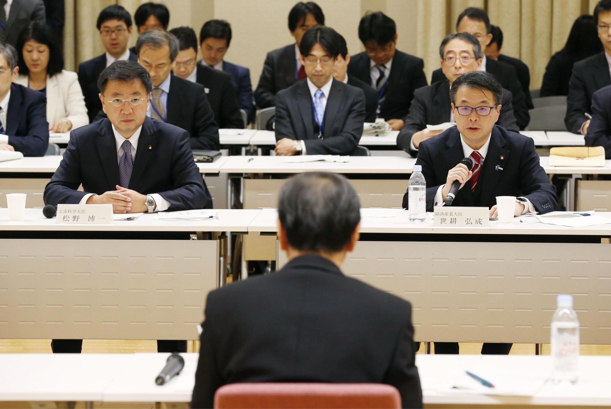Industry minister Hiroshige Seko (right) speaks to Fukui Gov. Issei Nishikawa (foreground) about the fate of the Monju fast-breeder reactor on Wednesday in Tokyo. | KYODO