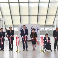 Tokyo Gov. Yuriko Koike, third from right, and the sports director for the 2020 Tokyo Olympic organizing committee and a 2004 Olympic hammer throwing champion, Koji Murofushi, third from left, attend a tape-cutting ceremony for the display of the Olympic and Paralympic flags at the Tokyo Metropolitan Government office on Nov. 1. | KYODO