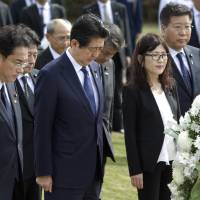 Paying their respects (from left) Sal Miwa of the Japan-America Society of Hawaii, Prime Minister Shinzo Abe, Defense Minister Tomomi Inada and Deputy Chief Cabinet Secretary Koichi Hagiuda bow at the Ehime Maru Memorial at Kakaako Waterfront Park, Monday in Honolulu. The memorial is dedicated to the victims of a 2001 deadly collision off the coast of Hawaii between the Ehime Maru, a fisheries training vessel, and a U.S. naval submarine. Abe plans to visit Pearl Harbor with U.S. President Barack Obama Tuesday. | AP