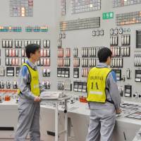 Workers in the control room restart reactor 1 at Kyushu Electric Power Co.\'s Sendai nuclear plant in Kagoshima Prefecture Thursday night. | KYODO