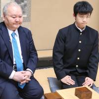 Professional shogi player Sota Fujii (right), 14, poses after defeating Hifumi Kato, 76, in his debut match Saturday in Tokyo\'s Shibuya Ward. Fujii is the youngest pro in the game. | KYODO