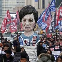 Protesters carry an effigy of South Korean President Park Geun-hye in Seoul. | AP