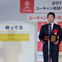 Hiroshima Carp superstar Seiya Suzuki collects a prize at the Buzzword Grand Prix ceremony in Tokyo for inspiring the winning term this year, \"kamitteru,\" with his \"superhuman behavior\" on the baseball field. | SATOKO KAWASAKI