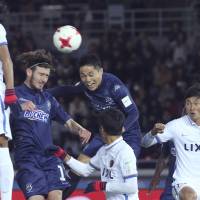 Auckland City\'s Kim Dae-wook (center), heads the ball to score his club\'s first goal against the Kashima Antlers during a Club World Cup match on Thursday at Nissan Stadium. | AP