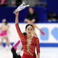 Mao Asada, who finished 12th, waves to the crowd after her free skate at the national championships on Sunday. | KYODO