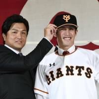 Yomiuri Giants manager Yoshinobu Takahashi (left) poses with new signing Daikan Yoh at a news conference in Tokyo on Monday. | KYODO