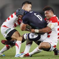 Japan\'s Yu Tamura (left) and Amanaki Lelei Mafi (right) tackle Scotland\'s Josh Strauss during their test match at Ajinomoto Stadium on June 25. The Brave Blossoms are scheduled to play Australia in Japan on Nov. 4, 2017. | KYODO