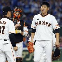 Giants pitcher Tetsuya Utsumi (right) has undergone surgery to remove a tumor but is expected to begin working out in January. | KYODO