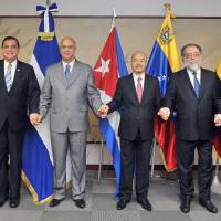 From left, Nicararagua\'s Ambassador, Saul Arana Castellon; Cuba\'s Ambassador Carlos M. Pereira; Venezuela\'s Ambassador Seiko Ishikawa; Ecuador\'s Ambassador Leonardo Carrion; and Bolivia\'s Charge d\'Affaires a.i. Angela Ayllon join hands during a reception to celebrate of the 12th anniversary of the foundation of the Bolivarian Alliance for the Peoples of Our America at the Latin American Salon, in Tokyo\'s Minato Ward on Dec. 22. | YOSHIAKI MIURA