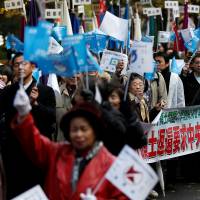 Protesters urge the return of four Russia-held islands off Hokkaido as they march in Tokyo Thursday ahead of Russian President Vladimir Putin\'s visit to Japan later this month. | REUTERS
