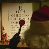 Santa Claus takes a vision test as part of his annual medical exam in this screen shot from a YouTube video by Transport Canada, which has renewed his commercial pilot\'s license and cleared him to fly for Christmas. | KYODO