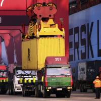 Trucks line up at a container port in Qingdao in east China\'s Shandong province in this Dec. 8 file photo. | AP