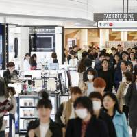Customers browse a duty-free shop in Tokyo\'s Ginza district. Kansai Airports has scrapped a plan to open a duty-free shop in central Osaka due to a slowdown in bakugai shopping sprees. | KYODO