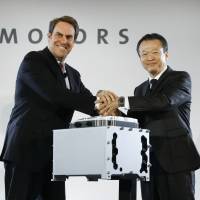 Mark Reuss (left), General Motors executive vice president of global product development, and Toshiaki Mikoshiba, chief operating officer of the North American region for Honda Motor Co., Ltd., shake hands at a news conference announcing a GM-Honda joint venture in Detroit on Monday. GM, Honda plan venture to develop advanced hydrogen fuel cells