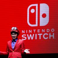 Nintendo\'s Yoshiaki Koizumi, clad as game character Super Mario, speaks at the launch of Switch, Nintendo\'s new game console, in Tokyo on Friday. | REUTERS
