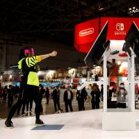 Demonstrators play Nintendo\'s \"Arms\" game with its new game console Switch at its experience venue in Tokyo on Friday. | REUTERS