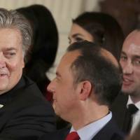 Chief White House strategist Steve Bannon (left) sits with Chief of Staff Reince Priebus (center) and senior adviser Stephen Miller during a swearing-in ceremony at the White House in Washington Jan. 22. | REUTERS