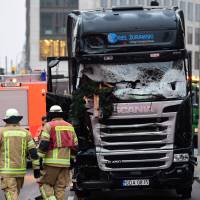 This Dec. 20 photo shows the truck at the scene where it crashed into a Christmas market near the Kaiser-Wilhelm-Gedaechtniskirche (Kaiser Wilhelm Memorial Church) in Berlin. German police in Berlin on Tuesday searched a home of asylum seekers where a 26-year-old Tunisian, who had contact with Anis Amri, lives and a second search took place in an apartment in Berlin housing a former roommate of the alleged perpetrator of the attack that killed 12 people. | AFP-JIJI