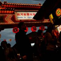 Tourists stroll through a food stall area at the Raohe street Night Market in Taipei on Wednesday. | REUTERS