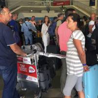 British and Dutch tourists check in at Banjul Airport, Gambia, Wednesday. Special flights were being organized Wednesday to evacuate British and other tourists from Gambia, where the threat of a regional military intervention loomed as President Yahya Jammeh\'s mandate expires on Thursday after he lost elections in December. | AP