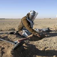 An Afghan de-miner searches for land mines in the Zhari district of Kandahar on Jan. 9. Twenty years after Diana campaign, new land-mine crisis plagues Iraq and Syria