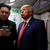 \"Howard,\" 37, an Australian-Chinese man impersonating North Korean leader Kim Jong Un, and Dennis Alan, a 66-year-old American impersonating U.S. President Donald Trump, ride a subway train in Hong Kong on Wednesday. | REUTERS