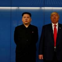 Dennis Alan, a 66-year-old American impersonating U.S. President Donald Trump, and \"Howard,\" a 37-year-old Australian-Chinese impersonating North Korean leader Kim Jong Un, wait for a subway train in Hong Kong on Wednesday. | REUTERS